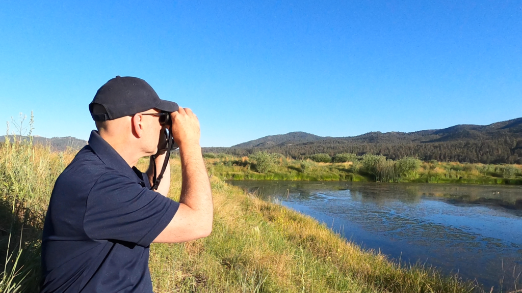 Birder overlooking a marsh and mountains beyond