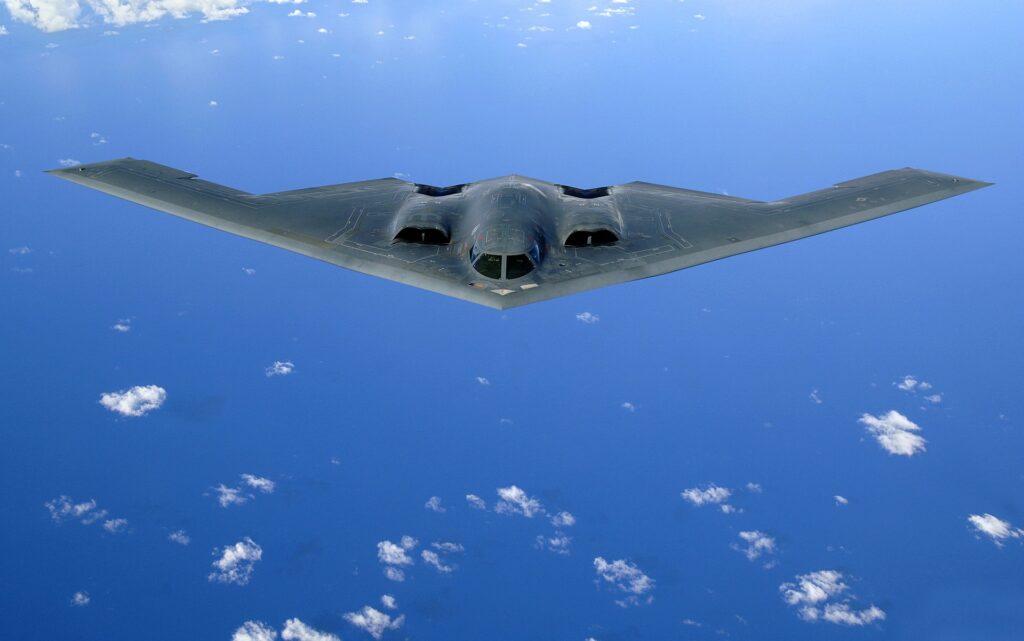 A B-2 bomber, shown from the front, sails as gracefully through a blue sky as the Peregrine Falcon, after which it was designed. 