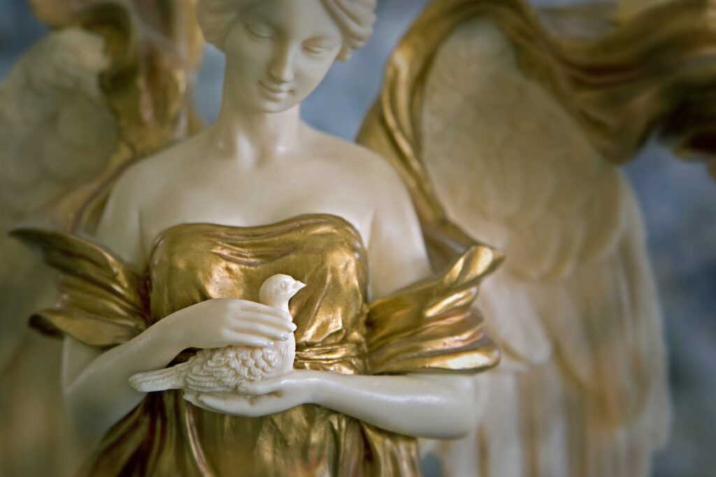 The statue of an angel holding a dove in her hands.
