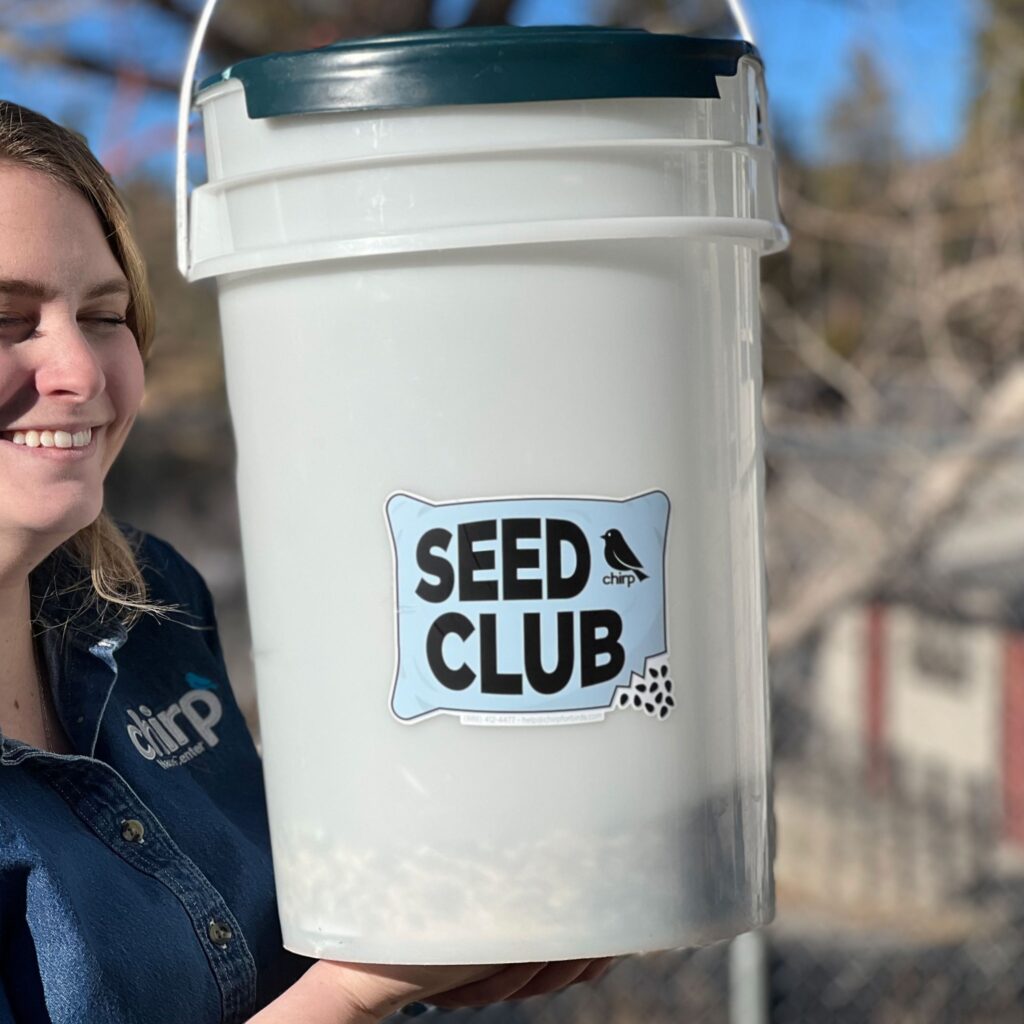 Chirp team member Joy holds a bucket of Chirp's proprietary Big Bear Blend seed mix, offered as part of Chirp's Seed Club.