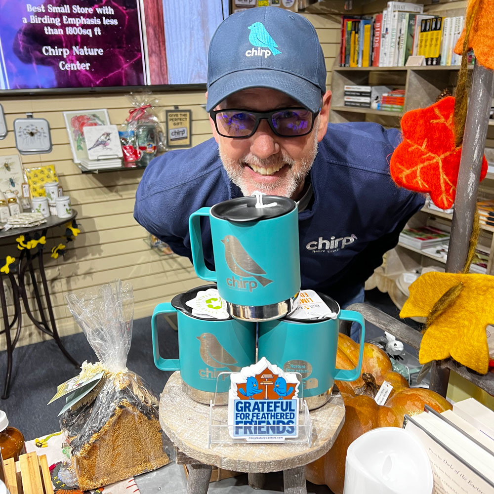 Chirp owner Randy poses with Chirp merch. A portion of every Chirp sale is donated to a nature preservation organization.
