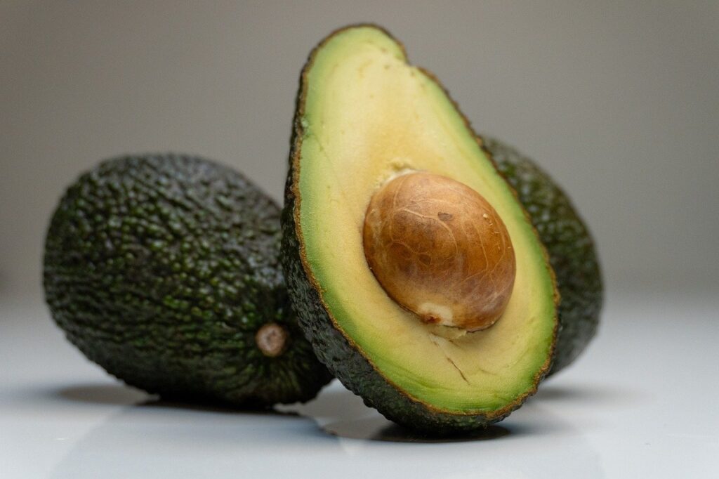 An avocado, shown halved with the pit.