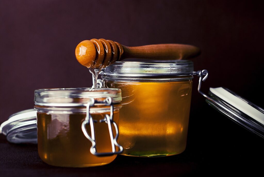 Two clear jars of honey.