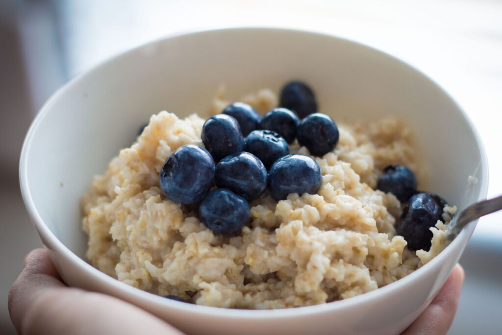 A bowl of fresh oatmeal topped with blueberries.