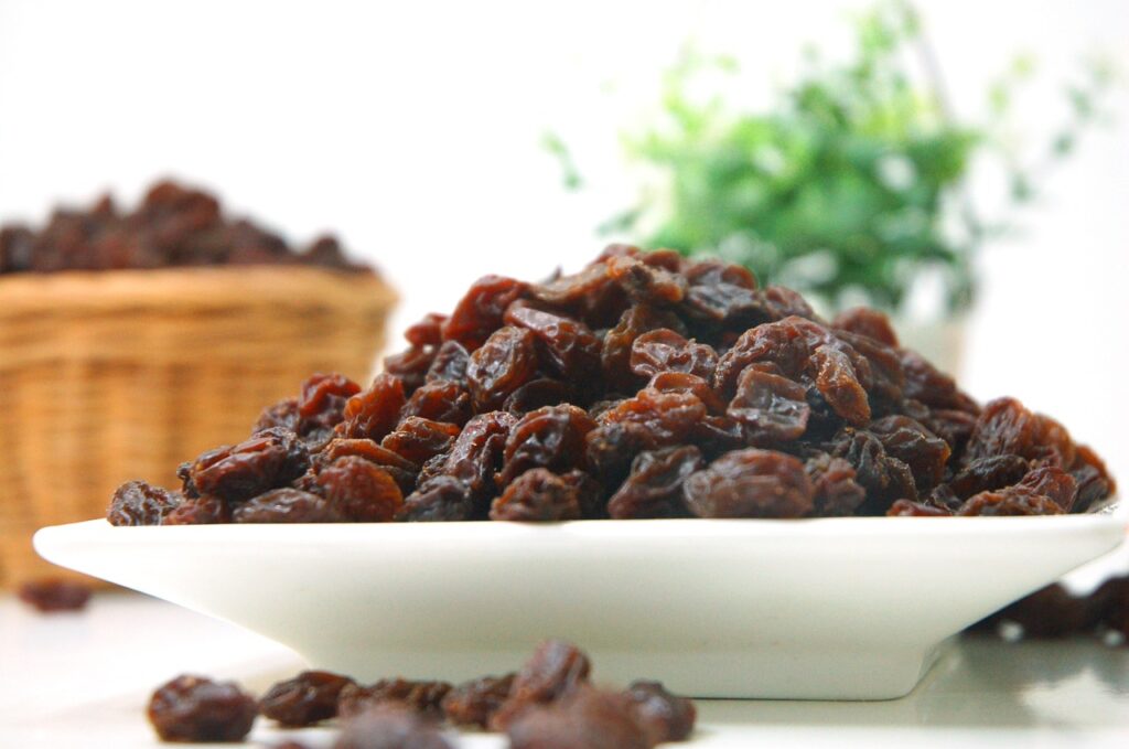 A white bowl heaped with raisins.