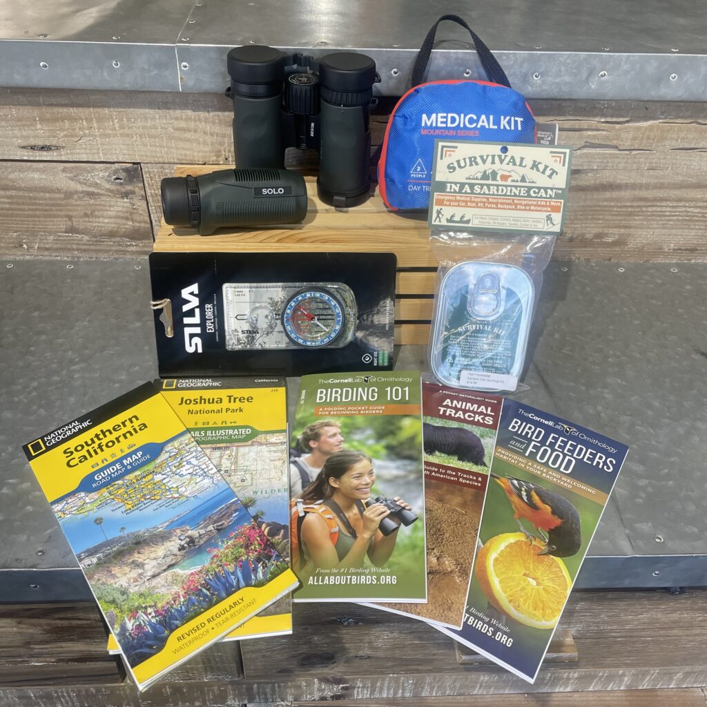 An assortment of birding gear--including field guides and binoculars--all available at the Chirp store.